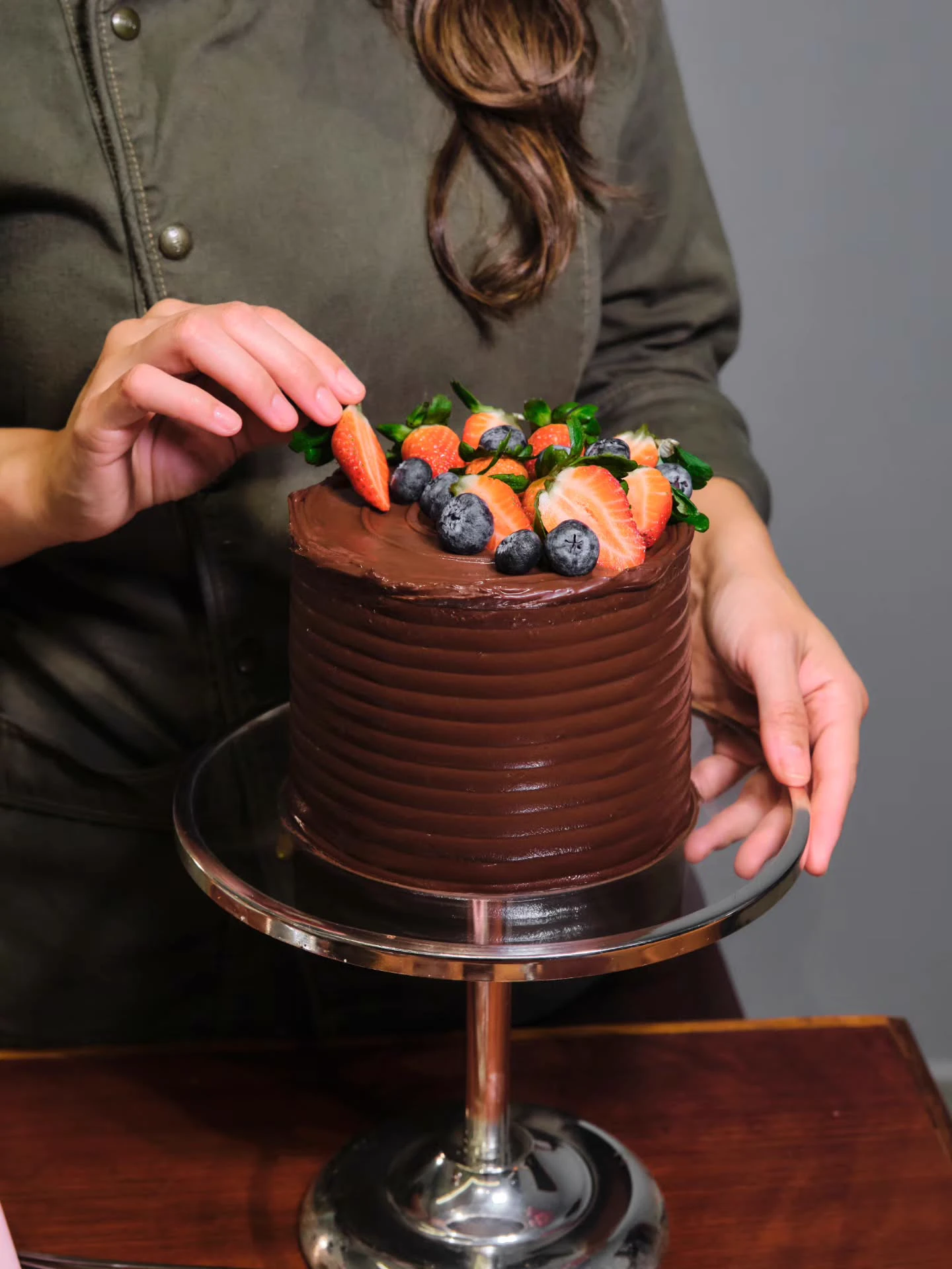 Bolo em Ganache de chocolate finalizado com morangos e mirtilos frescos pela confeiteira Nathália
